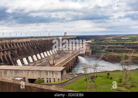 Itaipu Binacional, Brasile - 22 giugno 2025: Ampia vista della centrale idroelettrica di Itaipu e dell'imponente muro della diga sopra il canale del fiume Parana. Foto Stock