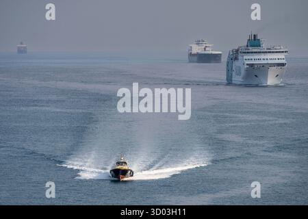 Pilota di porto che naviga di fronte alle navi che accedono al porto di Barcellona, Catalogna, Spagna Foto Stock