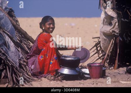 Donna Tamil che pulisce pentole e padelle. Karaiyar- Tamil costiero anni '1990 Comunità Tamil, sono una casta di pescatori e marinai. La comunità tamil dello Sri Lanka vive in rifugi di legno sulla spiaggia a sud di Colombo, Sri Lanka. 1990s 1995 HOMER SYKES Foto Stock