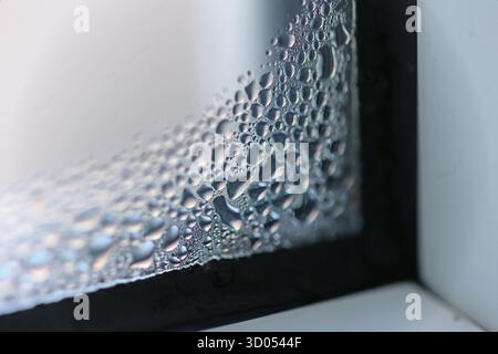 Primo piano di goccioline d'acqua di condensazione sul vetro della finestra Foto Stock