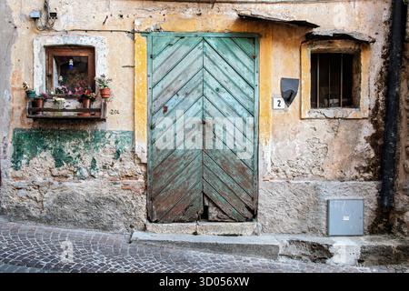 Vecchia porta in legno e facciata intemprata nello storico villaggio di stilo, Calabria, Italia meridionale Foto Stock