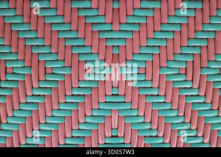 Tappeto in plastica intrecciata con un motivo geometrico in moderno verde menta pastello e beige rosa. Primo piano sfondo astratto ideale per l'uso nella progettazione. Foto Stock