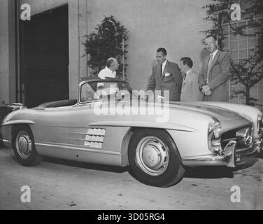 Tre venditori che parlano con un cliente maschile di una Mercedes convertibile classica Foto Stock