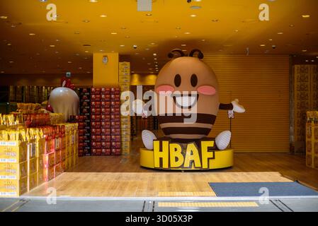Il 27 gennaio 2024, un grande personaggio delle api cartoni animati accoglie i visitatori in un negozio di spuntini HBAF nel quartiere dello shopping di Myeongdong a Seoul, Corea del Sud Foto Stock