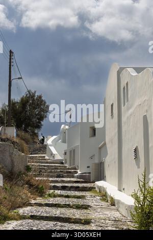 Tradizionali edifici in bianco e strada acciottolata a Santorini, Grecia Foto Stock