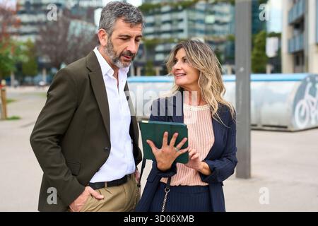 Colleghi aziendali che discutono di progetti con tablet digitali all'aperto Foto Stock