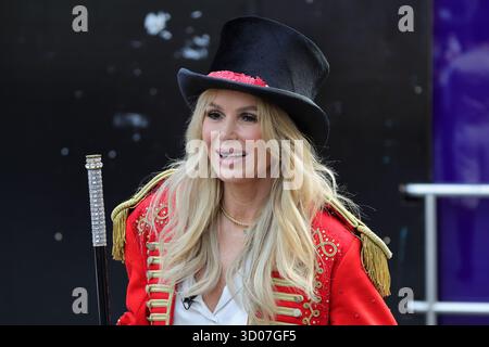 Londra, Regno Unito. 21 ottobre 2025. Amanda Holden al di fuori degli studi Global radio in un vestito da maestro di ring con membri del cast di come Alive Circus Spectacular, ora in scena all'Earls Court di Londra. Foto Stock