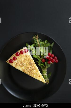 Un pezzo di deliziosa torta decorata con albero di Natale e frutti di bosco rossi Foto Stock