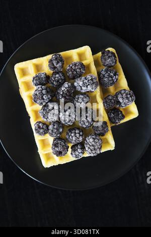 Cialde belghe con congelati more su sfondo nero Foto Stock
