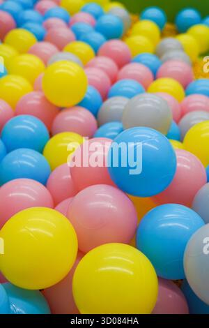 Una pila di palline colorate di plastica in varie tonalità come blu, rosa, giallo e grigio Foto Stock
