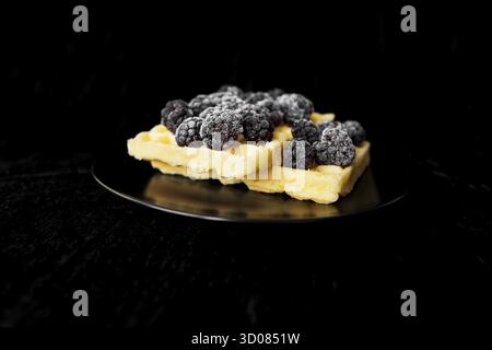 Cialde belghe con congelati more su sfondo nero Foto Stock