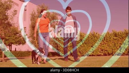 Coppia che cammina mano nella mano nel cortile anteriore, con cane bianco nero al guinzaglio, copertura del cuore Foto Stock