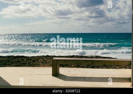 Questa pittoresca e tranquilla scena costiera presenta onde dolci e un'atmosfera veramente serena Foto Stock