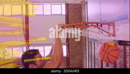 Un giocatore di basket senza maniche in maglia e pantaloncini corti, un bordo arancione e una rete in palestra Foto Stock