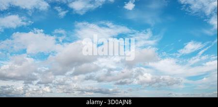 Il panorama del cielo è ricco di nuvole, dal soffice cumulus al ragno cirrus, che si estende attraverso l'orizzonte in una giornata luminosa e limpida. Foto Stock