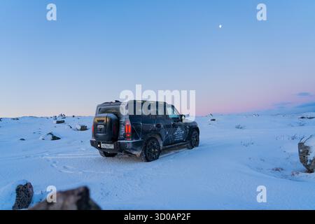 Murmansk, Russia - 13 dicembre 2024: Vista posteriore del SUV Jetour T2 nella neve profonda sotto la luna artica. Vista posteriore di un SUV Jetour T2 nero parcheggiato in va Foto Stock