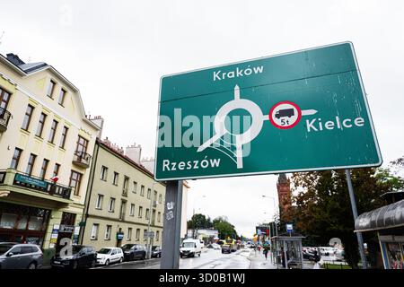 Tarnow, Polonia - 10 ottobre 2025: Segnale stradale verde a Tarnow Polonia indirizza a Cracovia Rzeszow Kielce con una scena urbana. Foto Stock