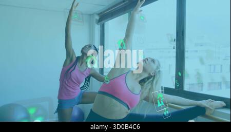 La gamba laterale performante allunga due donne sportive che si allenano in palestra, con sbarre e palle Foto Stock