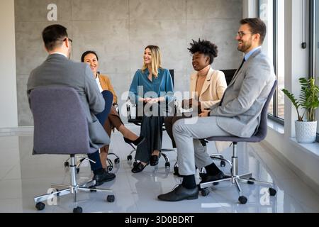 Persone d'affari diverse sedute in cerchio alla sessione di terapia di gruppo. Personale addetto alla formazione dei Business Coach Foto Stock