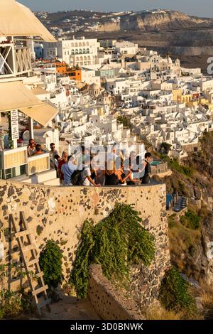 Fira, Santorini, Grecia - 24 agosto 2025: Folla dell'ora d'oro affacciata sul Villaggio bianco di Fira Foto Stock