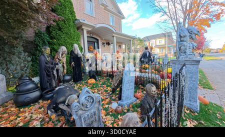 Toronto, ON, Canada - 22 ottobre 2025: Un cortile anteriore presenta elaborate decorazioni di halloween di fronte a una grande casa. Foto Stock