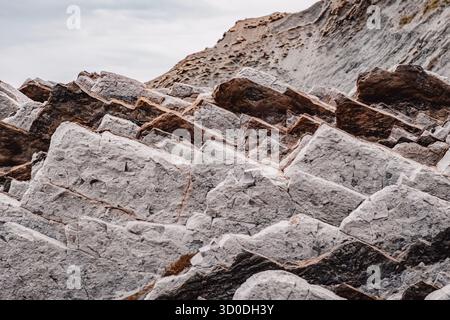 Formazione rocciosa sedimentaria stratificata che mostra strati geologici, modelli di erosione naturale, strati di pietra bianchi e marroni, dettagli superficie testurizzata Foto Stock