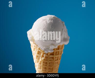 gelato alla vaniglia con cono per waffle su sfondo blu Foto Stock