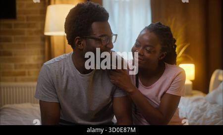 Felice amorevole abbracciando la famiglia afroamericana sposata gioiosa coppia ritratti coniugi uomo marito e donna moglie abbracciando coccole letto a guardare Foto Stock