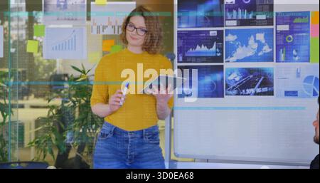 Presentando una donna che indossa la parte superiore della mostarda, con un pennarello blu e un tablet Foto Stock