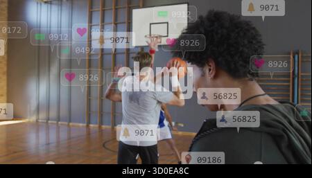 Osservando il coach con il fischio che monitora i giocatori che sparano a cerchio nelle bolle di notifica della palestra Foto Stock