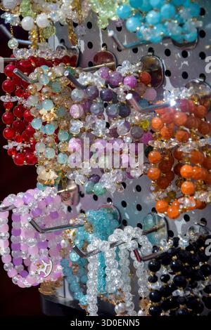 Vetrina con bracciali da donna realizzati in pietre naturali multicolore. Commercio di strada. Primo piano. Foto Stock