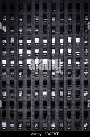 Luce blu esterna sulle finestre di un alto edificio di uffici Foto Stock