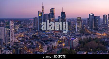 Vista aerea della Torre principale e di altri grattacieli che piangono il cielo crepuscolo, proiettando lunghe ombre sulle strade della città, Francoforte sul meno, Assia, Germania. Foto Stock