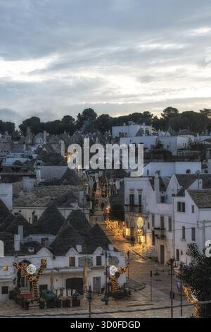 Luce del tramonto sulle case dei Trulli con tetti conici ad Alberobello Foto Stock