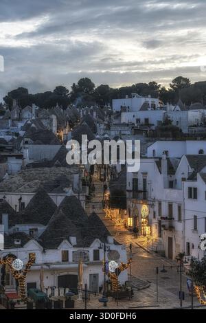 Luce del tramonto sulle case dei Trulli con tetti conici ad Alberobello Foto Stock