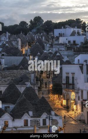 Luce del tramonto sulle case dei Trulli con tetti conici ad Alberobello Foto Stock