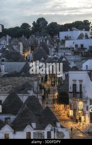 Luce del tramonto sulle case dei Trulli con tetti conici ad Alberobello Foto Stock