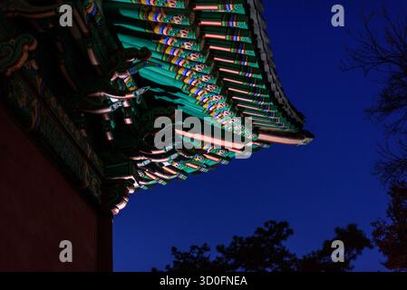 Il tradizionale tetto del tempio coreano con motivi colorati contro un cielo blu profondo a Seoul, Corea del Sud, il 29 gennaio 2024 Foto Stock