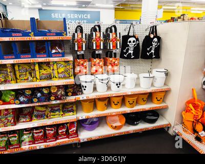 Manchester, Regno Unito - 26 settembre 2025: Luminoso spettacolo a tema Halloween con caramelle, secchi di zucca e borse teschio su uno scaffale del negozio. Foto Stock