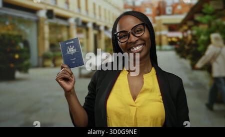Una donna in maglia gialla ha il passaporto australiano sorridente sulla strada urbana, rappresentando la felicità dei viaggi e la diversità culturale in una città all'aperto setti Foto Stock