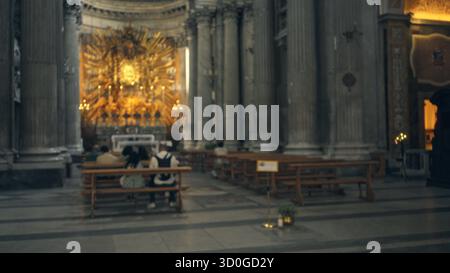 Interni della chiesa sfocati e ornati con un poco profondo effetto bokeh su altare dorato lontano e colonne di pietra alte, morbido defocato in primo piano; sfondo copyspac Foto Stock