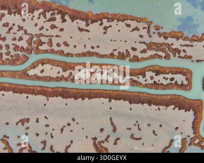 Veduta aerea del netto contrasto tra i corsi d'acqua color acqua che attraversano la terra marrone e strutturata, creando un ipnotico arazzo visto dall'alto, Salonicco, Salonicco, Grecia. Foto Stock