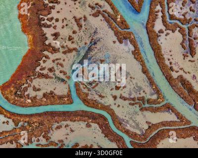 Vista aerea dei tortuosi corsi d'acqua scavati nella terra, un arazzo di tonalità ocra e turchese che si fondono nel sereno abbraccio del paesaggio, Salonicco, Salonicco, Grecia. Foto Stock