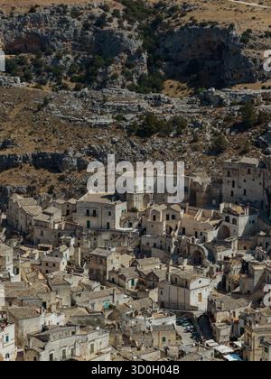 Vista aerea di antiche abitazioni incastonate nella collina rocciosa, un paesaggio senza tempo di pietra e terra baciata dal sole, Matera, Basilicata, Italia. Foto Stock