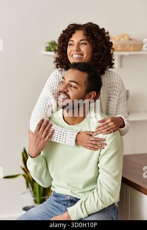 Una felice coppia afroamericana si gode la compagnia l'una dell'altra nella loro casa luminosa. Foto Stock