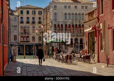Una donna cammina verso una stazione della Gondola su Rio Terà San Silvestro vicino al Canal grande a San Marco, Venezia, Italia Foto Stock
