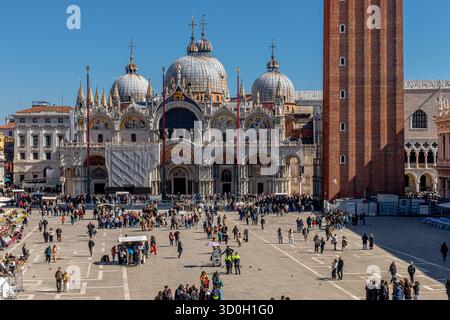Folle in Piazza San Marco con le cupole bizantine della basilica di San Marco all'estremità orientale di Piazza San Marco a Venezia Foto Stock