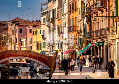 Persone che camminano lungo fondamenta de la Misericordi, vicino a Ponte San Marziale, un ponte sul canale nel Cannaregio sestiere di Venezia Foto Stock