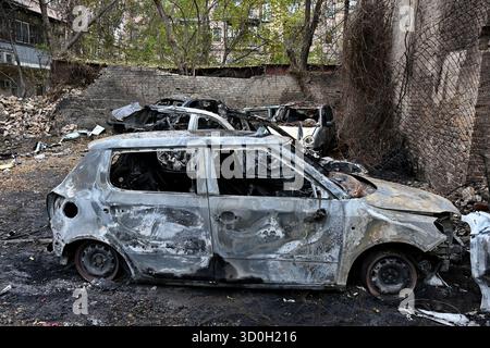 Kiev, Ucraina. 23 ottobre 2025. Auto bruciate vicino a un condominio danneggiato in uno sciopero notturno di droni russi in mezzo all'attacco russo all'Ucraina, a Kiev, Ucraina, 23 ottobre 2025. Credito: SOPA Images Limited/Alamy Live News Foto Stock