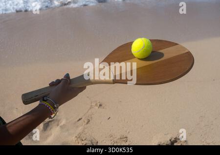 La donna tiene raquet e palla sulla spiaggia in estate, costa settentrionale, Egitto Foto Stock